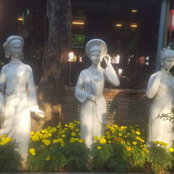 Statue amidst flowering plants at store