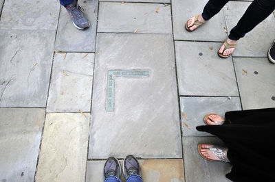 Low section of people standing on tiled floor