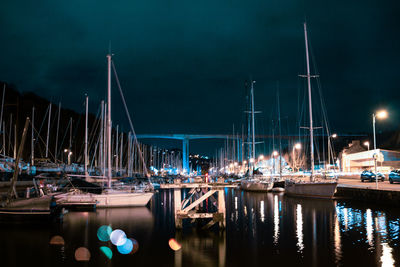 Boats moored in harbor at night