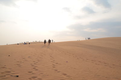 People at beach against sky