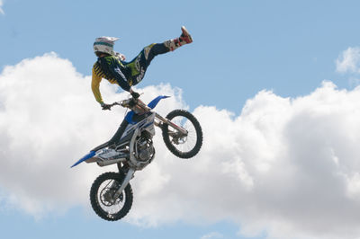 Low angle view of man riding motorcycle against sky