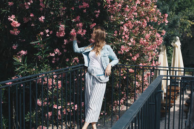 High angle view of woman standing by railing against trees