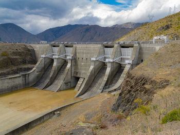 High angle view of dam and mountains against sky