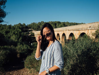 Woman standing against arch bridge