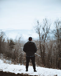 Rear view of man standing on snow field