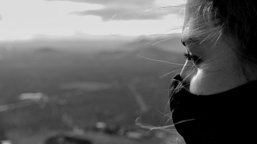 Close-up portrait of young woman against sky