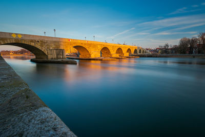 Arch bridge over river against sky