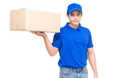 Portrait of salesman with cardboard box standing against white background