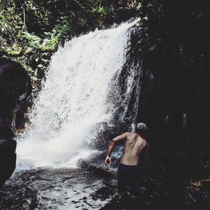 Man splashing water in waterfall