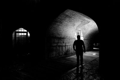 Rear view of man standing in tunnel