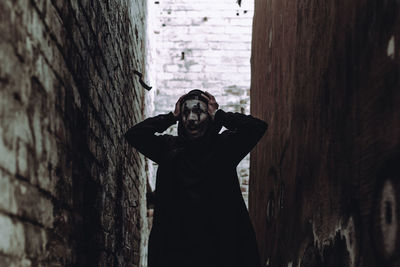 Young man standing amidst wall