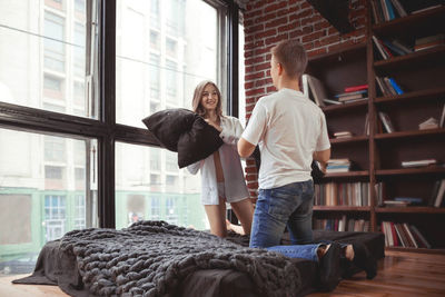 Side view of young woman looking through window