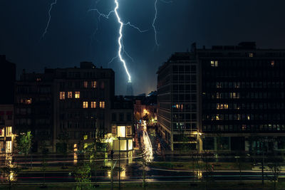 Illuminated buildings in city against sky at night