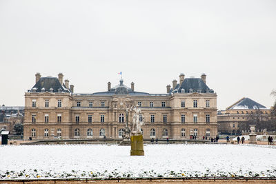 Buildings in city against clear sky during winter