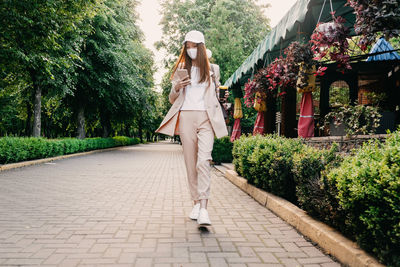 Redhead woman wearing face mask for virus protection. young business woman with cell phone in hand