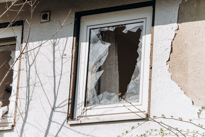 Low angle view of broken window in abandoned building