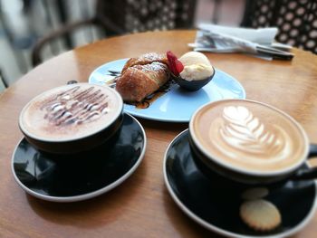 High angle view of cappuccino and coffee on table