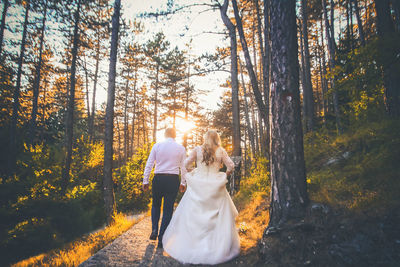 Rear view of couple walking in forest