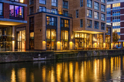 New housing development with quayside hospitality on the ground floor reflecting in canal