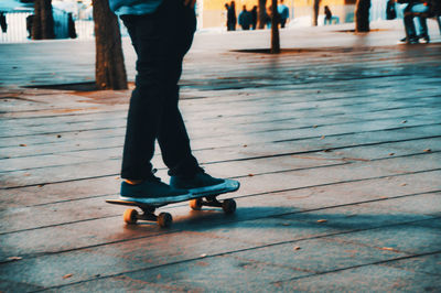 Low section of man skateboarding on street