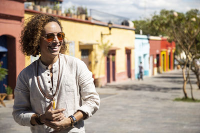 Man smiling at colorful colonial-building street in oaxaca, mexico