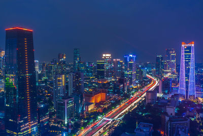 Illuminated buildings in city against sky at night