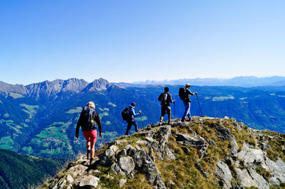 People on mountain against clear sky