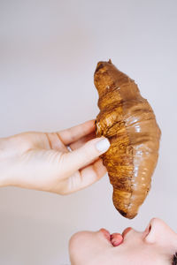 Midsection of person holding ice cream against white background