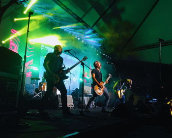 People playing guitar at music concert