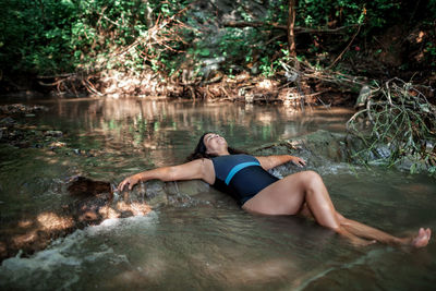 Middle aged woman bathing in stream canyon river in the mountains, nature pool. cold natural spa