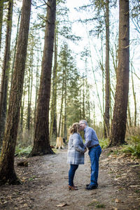 Elderly couple kissing in the woods.