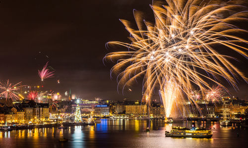 Firework display over river at night