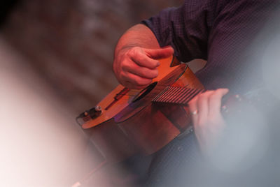 Close-up of man playing ukulele