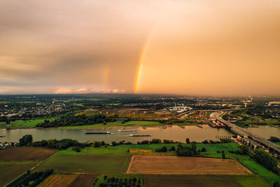 Scenic view of rainbow over buildings in city against sky