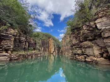 Panoramic view of rock formation amidst trees against sky