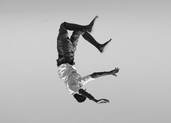 Low angle view of man jumping against white background