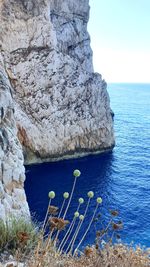 Scenic view of rock formation in sea against sky