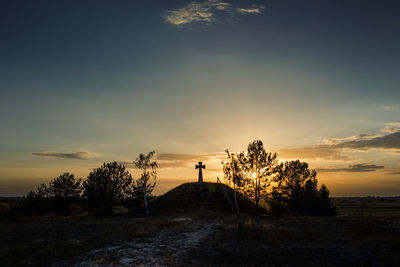 Silhouette person standing on field against sky during sunset