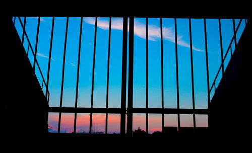 Low angle view of glass window at sunset