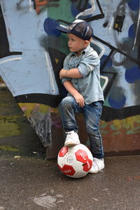 Boy with ball standing in park