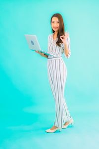 Young woman standing against blue background