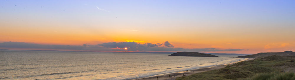 Scenic view of beach against sky during sunset