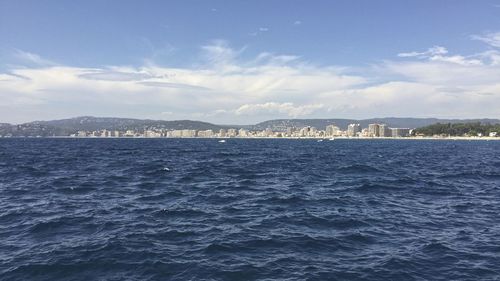 Scenic view of sea by buildings against sky