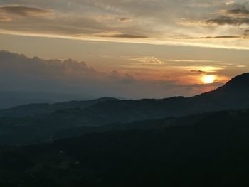 Scenic view of silhouette mountains against sky during sunset