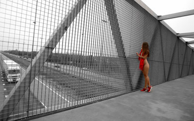 Side view of woman with umbrella walking on road