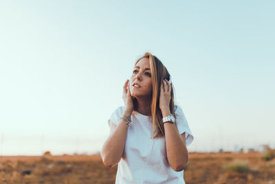 Mid adult woman standing against sky