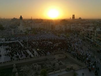 High angle view of crowd in town against sky during sunset