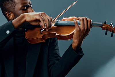 Midsection of man playing violin