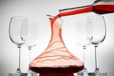 Close-up of wineglass on table against white background