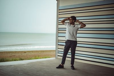 Full length of man standing by beach against sky